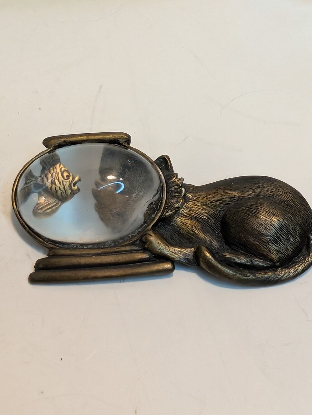A vintage Jonette Jewelry (JJ) brooch featuring a pewter cat eyeing a fish.